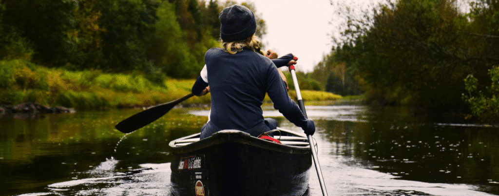 Jongedame aan het kanoën in een rivier