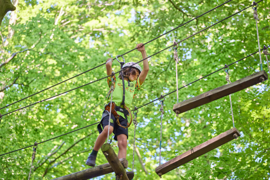 Jongetje houdt zich vast om een stap te zetten naar het volgende onderdeel.