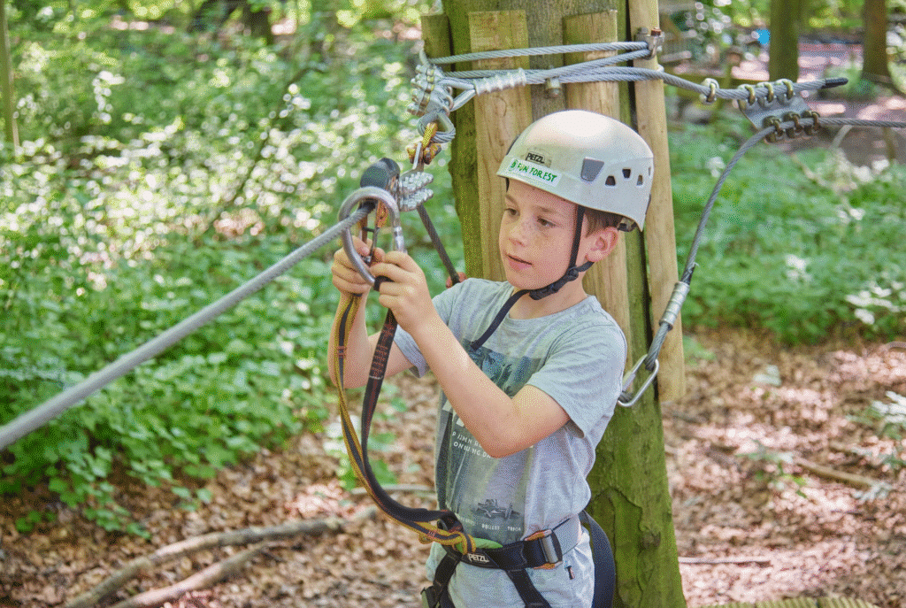 Jongetje met witte helm oefent met zijn katrol en zaza op de grond bij Fun Forest