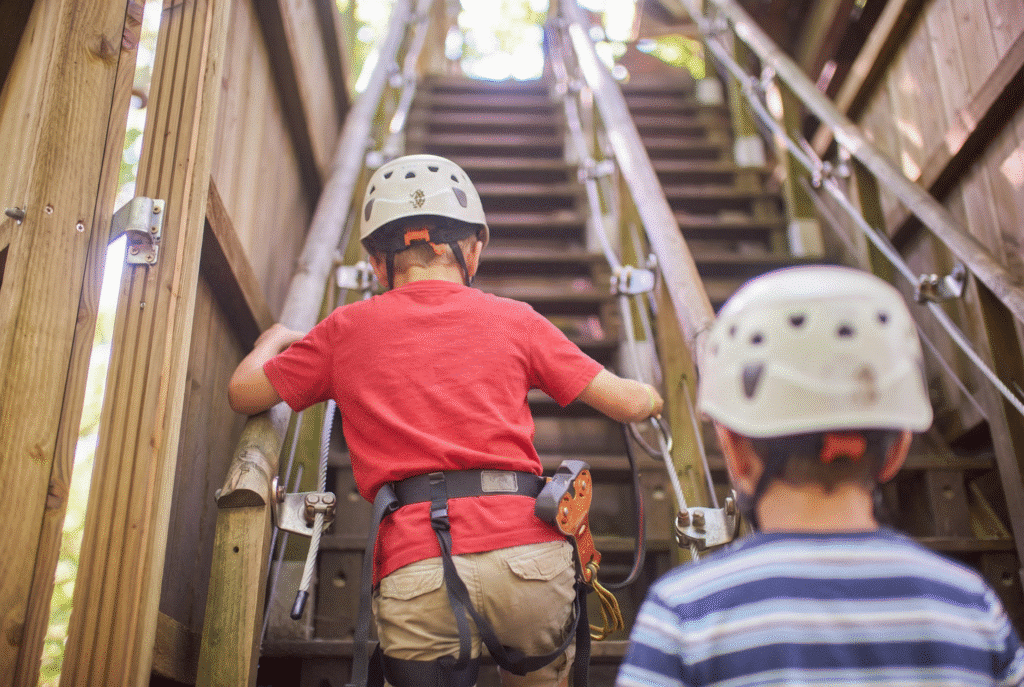 Twee jongetjes met een witte helm lopen de trap bij het hoofdplatform op.