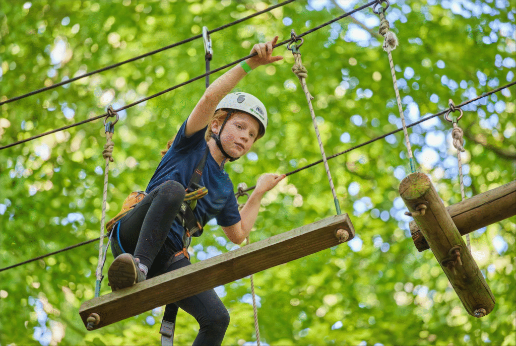 Meisje met een witte helm en blauw shirt heeft haar voet op een bewegende houten balk.